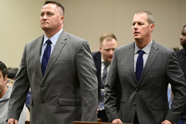 FILE - Paramedics Jeremy Cooper, left, and Peter Cichonek attend an arraignment at the Adams County Justice Center in Brighton, Colorado, on Jan. 20, 2023. The two paramedics on trial for the 2019 death of Elijah McClain told investigators in videotaped interviews never before seen by the public. The 23 year old black man has "Excited delirium