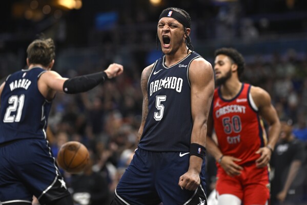 Orlando Magic forward Paolo Banchero (5) celebrates his dunk against the New Orleans Pelicans during the second half of an NBA basketball game Thursday, March 21, 2024, in Orlando, Fla. (AP Photo/Phelan M. Ebenhack)