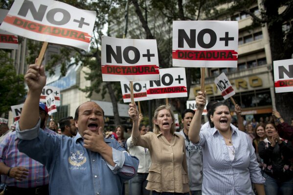 
              People holding signs with a message that reads in Spanish: "No more dictatorship" take part in a walkout against President Nicolas Maduro, in Caracas, Venezuela, Wednesday, Jan. 30, 2019. Doctors in scrubs, businessmen in suits and construction workers in jeans gathered on the streets of Venezuela's capital Wednesday, demanding Maduro step down from power in a walkout organized by the nation's reinvigorated opposition to ratchet up pressure on the embattled president. (AP Photo/Ariana Cubillos)
            