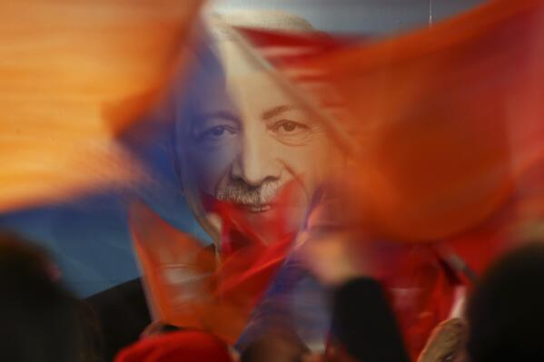 FILE - Supporters of President Recep Tayyip Erdogan wave flags in front of his picture in Istanbul, on March 31, 2019. Erdogan, who is seeking a third term in office as president in elections in May, marks 20 years in office on Tuesday, March 14, 2023. (AP Photo/Emrah Gurel, File)