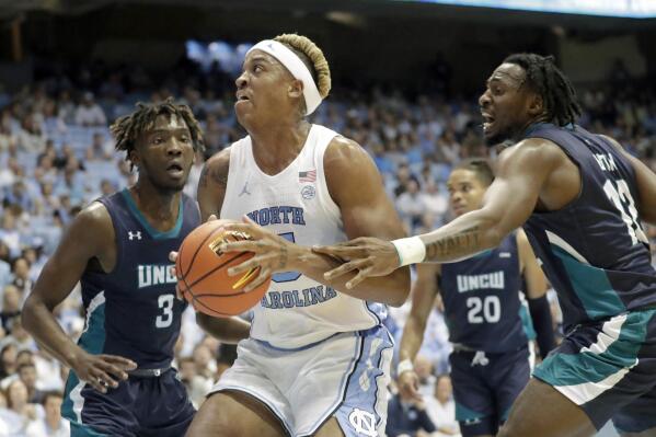 North Carolina forward Armando Bacot (5) drives against UNC Wilmington guard Maleeck Harden-Hayes (3) and center Victor Enoh (12) during the first half of an NCAA college basketball game in Chapel Hill, N.C., Monday, Nov. 7, 2022. (AP Photo/Chris Seward)