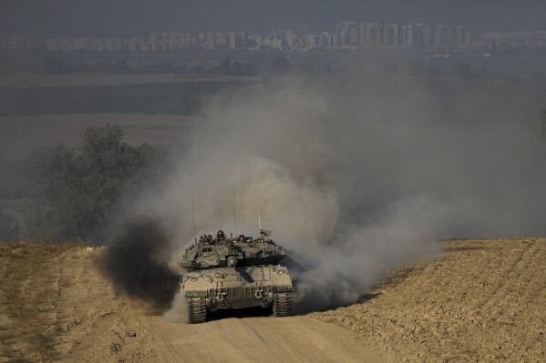 Israeli soldiers drive a tank near the Israeli-Gaza border, in southern Israel, Wednesday, June 5, 2024. (AP Photo/Tsafrir Abayov)