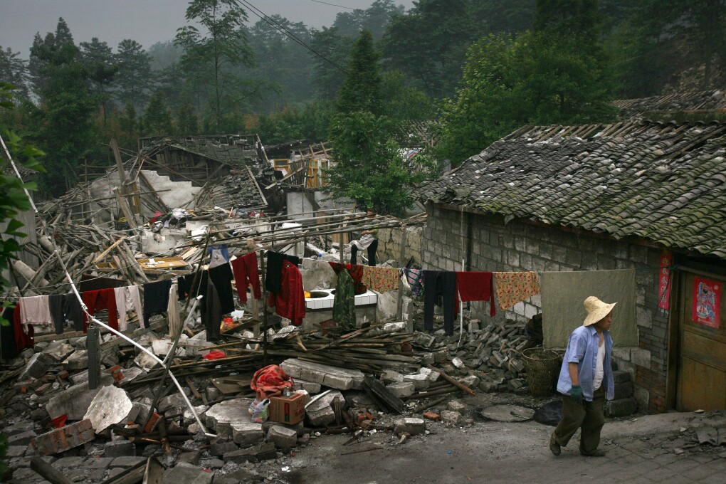 A Chinese earthquake survivor walks through the ruins of his neighborhood near the town of Hongbai of Shifang county, in China's southwest Sichuan province Friday, May 23, 2008. The May 12 quake killed more than 55,000, and more than 5 million people in Sichuan province remain homeless. (AP Photo/David Guttenfelder)