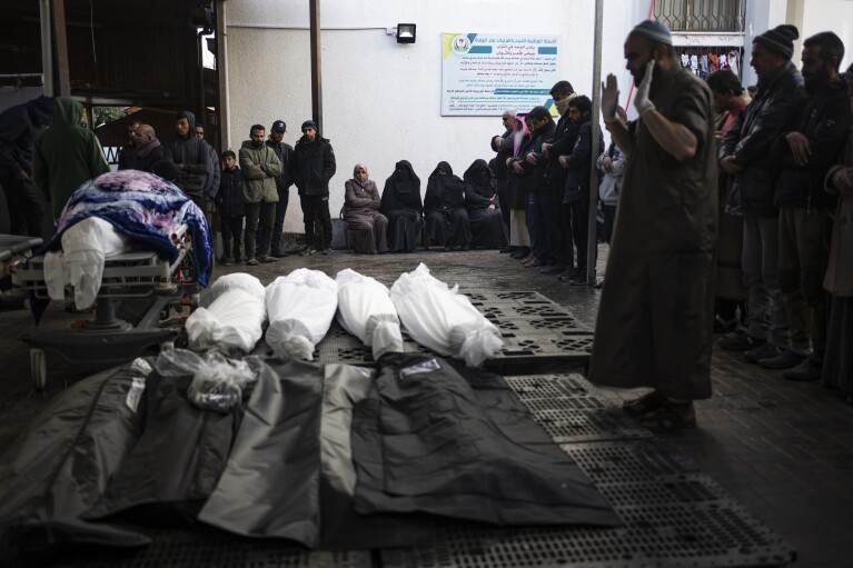 Palestinians pray next to the bodies of those who were killed in the Israeli ground offensive and bombardment of Khan Younis, outside a morgue in Rafah, southern Gaza, Wednesday, Jan. 24, 2024. (AP Photo/Fatima Shbair)