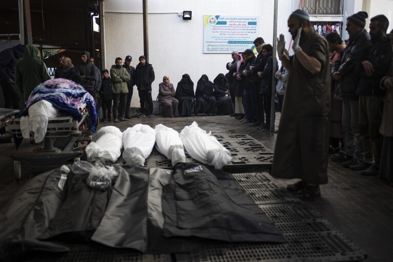 Palestinians pray near the bodies of those killed in the Israeli ground attack and bombing of Khan Younis, outside a morgue in Rafah, southern Gaza, on Wednesday, January 24, 2024.  (AP Photo/Fatima Shabair)