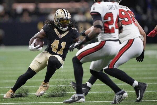 New Orleans Saints running back Alvin Kamara (41) comes under pressure from Tampa Bay Buccaneers cornerback Carlton Davis III (24) and linebacker Anthony Nelson (98) as he runs after catching a pass in the first half of an NFL football game in New Orleans, Sunday, Oct. 1, 2023. (AP Photo/Gerald Herbert)