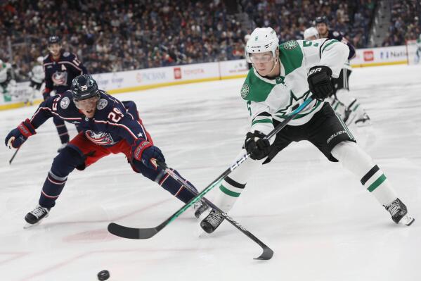 Dallas Stars' Nils Lundkvist, right, passes the puck past Columbus Blue Jackets' Patrik Laine during the third period of an NHL hockey game on Monday, Dec. 19, 2022, in Columbus, Ohio. (AP Photo/Jay LaPrete)