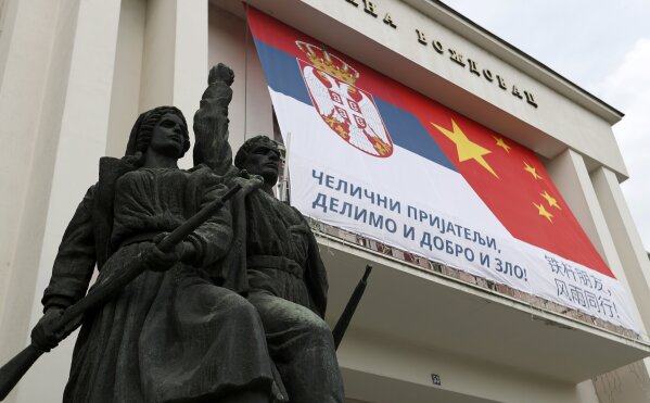 In this April 13, 2020, photo, a municipal office building decorated with billboard showing Serbian and Chinese flags reading: "Iron friends, together in good and evil!" prior to a curfew set up to help prevent the spread of the new coronavirus in Belgrade, Serbia. China is struggling to polish its image that was tarnished by its initial handling of the deadly COVID-19 coronavirus outbreak, trying to change perceptions through a combination of soft power policy, political messaging and aid that is designed to portray its leadership as a generous and efficient ally. (AP Photo/Darko Vojinovic)