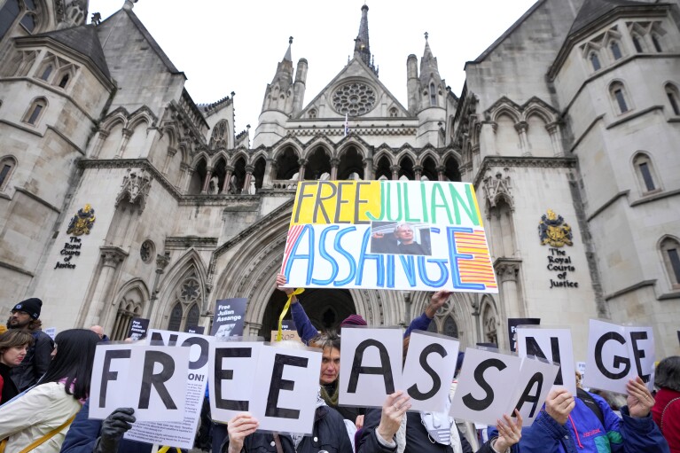 Demonstrators hold banners outside the Royal Courts of Justice in London, Tuesday, Feb. 20, 2024. WikiLeaks founder Julian Assange will make his final appeal against his impending extradition to the United States at the court. (AP Photo/Kirsty Wigglesworth)