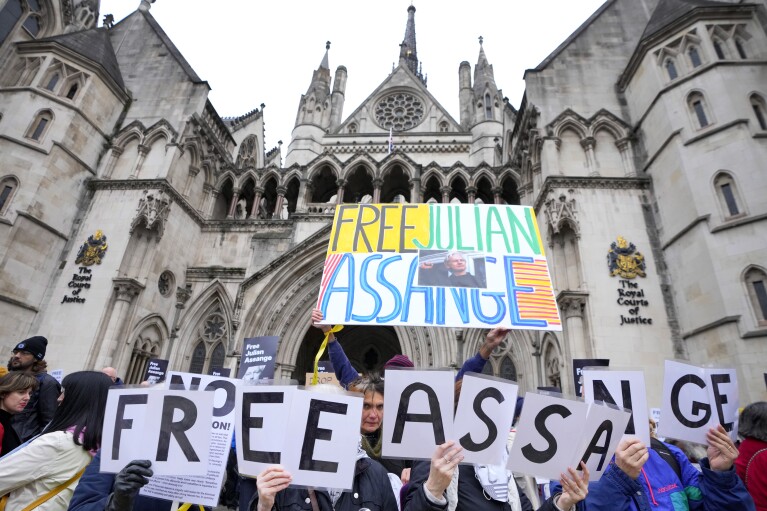 Manifestantes sostienen pancartas frente a los Tribunales Reales de Justicia en Londres, el martes 20 de febrero de 2024. El fundador de WikiLeaks, Julian Assange, presentará ante el tribunal su apelación final contra su inminente extradición a Estados Unidos.  (Foto AP/Kirsty Wigglesworth)