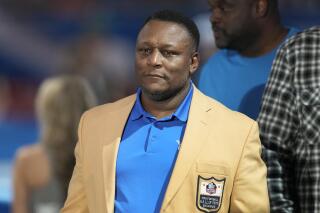 Former Detroit Lions running back Barry Sanders listens during a halftime ceremony of an NFL football game against the Miami Dolphins in Detroit, Sunday, Oct. 30, 2022. The Detroit Lions announced at halftime that Sanders will have his legacy permanently cemented in Detroit with a statue at Ford Field. Sanders will be the first Lions player to be immortalized with a statue. (AP Photo/Paul Sancya)
