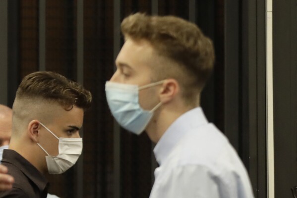 FILE - Gabriel Natale-Hjorth, left, walks past Finnegan Lee Elder, as he arrives ahead of a hearing for the trial of the two American tourists accused of killing paramilitary police officer Mario Cerciello Rega, in Rome, Wednesday, Sept. 9, 2020. Italy's highest Cassation Court ordered a new trial last year saying that it had not been proven beyond a reasonable doubt that the defendants, with limited Italian language skills, had understood that they were dealing with Italian police officers when they went to meet with an alleged drug dealer. (AP Photo/Alessandra Tarantino, Pool, file)