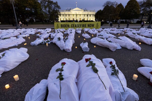 FILE - A large banner reading "Biden: Ceasefire Now" along with fake white body bags, representing those killed in the escalating conflict in Gaza and Israel, is displayed in front of the White House at dusk on Nov. 15, 2023, in Washington. (AP Photo/Andrew Harnik, File)