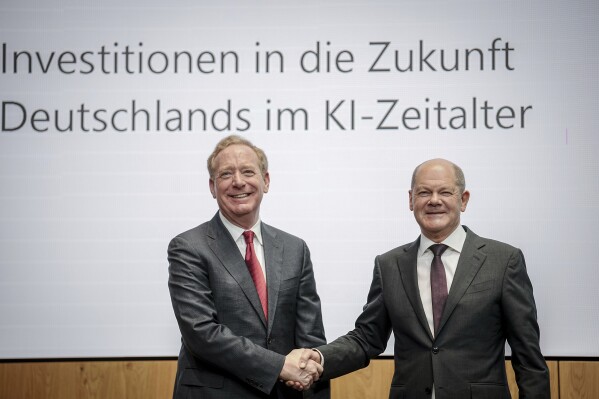 Federal Chancellor Olaf Scholz, right, and Vice Chair and President of Microsoft Corporation Brad Smith shake hands in Berlin, `Thursday, Feb. 15, 2024, after a press conference held by Microsoft Deutschland GmbH on the company's investments in the AI sector in Germany. Chancellor Olaf Scholz welcomed an announcement by Microsoft on Thursday that it would invest more than 3.2 billion euros ($3.4 billion) in Germany over the next two years to massively expand its data center capacities for applications in the field of artificial intelligence and cloud computing. (Kay Nietfeld/dpa via AP)