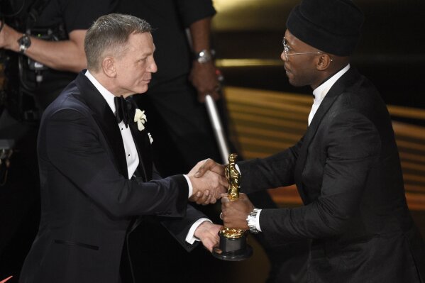 
              Daniel Craig, left, presents Mahershala Ali with the award for best performance by an actor in a supporting role for "Green Book" at the Oscars on Sunday, Feb. 24, 2019, at the Dolby Theatre in Los Angeles. (Photo by Chris Pizzello/Invision/AP)
            