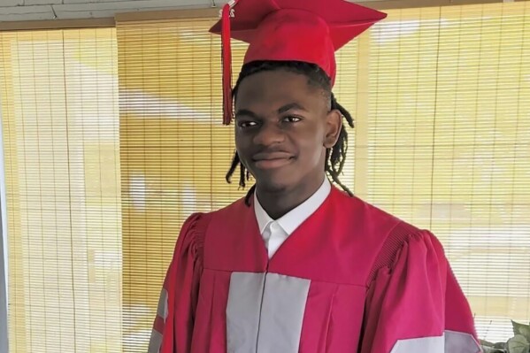 This undated photo provided by Luckner Joachin shows A.J. Laguerre with his cap and gown for his 2020 high school graduation. Laguerre, 19, was an employee at the Dollar General store in Jacksonville, Fla., where he and two other Black people were killed Saturday, Aug. 26, 2023. The local sheriff said the gunman, who took his own life, targeted all three victims because of their race. (Luckner Joachin via AP)