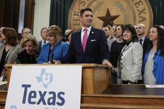FILE - In this March 7, 2019 file photo, State Rep. Jeff Leach, at podium, stands with fellow lawmakers and guests to talk about the Texas Born-Alive bill, in Austin, Texas. Leach, a Republican lawmaker is blocking a bill that would allow the death penalty for women seeking abortions says local authorities are monitoring his home near Dallas. A Texas sheriff's department said Thursday, April 11, 2019 it had "security concerns" over social media posts targeting Leach, who has come under fire by some conservative activists after blocking a bill that could lead to a woman being charged with homicide if she has an abortion. (AP Photo/Eric Gay, File)