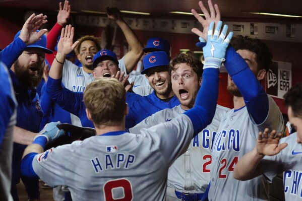 Chicago Cubs' Ian Happ, front left, celebrates his grand slam against the Arizona Diamondbacks with teammates, including Nico Hoerner (2) and Cody Bellinger (24), during the seventh inning of a baseball game Tuesday, April 16, 2024, in Phoenix. (AP Photo/Ross D. Franklin)