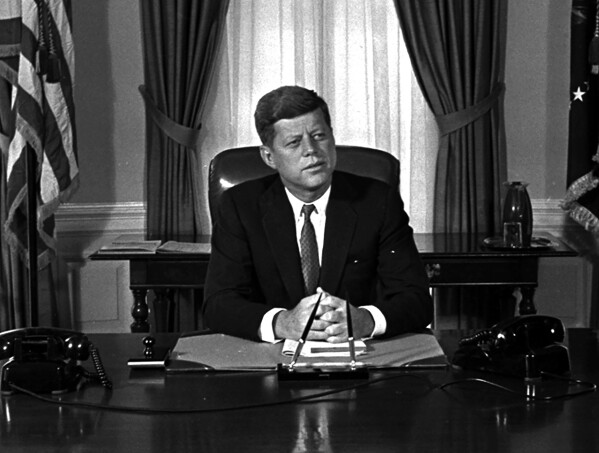 Newly-elected President Kennedy posed for first pictures at his White House desk, Jan. 21, 1961, before plunging into a busy round of conferences. (AP Photo/Bill Achatz, File)