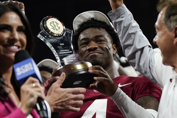 Alabama quarterback Jalen Milroe (4) holds up the most valuable player trophy after the Southeastern Conference championship NCAA college football game against Georgia in Atlanta, Saturday, Dec. 2, 2023. (AP Photo/Mike Stewart)