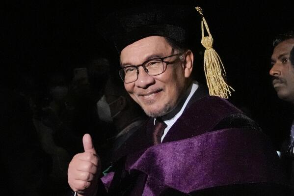 Malaysia's Prime Minister Anwar Ibrahim flashes the thumbs-up sign after he is conferred a Doctor of Laws degree, honoris causa during rites at the University of the Philippines in Quezon city, Philippines on Thursday March 2, 2023. (AP Photo/Aaron Favila)