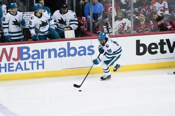 San Jose Sharks left wing Anthony Duclair (10) advances the puck during the first period of an NHL hockey game against the New Jersey Devils in Newark, N.J., Friday, Dec. 1, 2023. (AP Photo/Peter K. Afriyie)