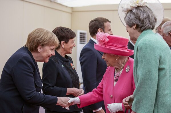FILE - In this Wednesday June 5, 2019 photo German Chancellor Angela Merkel, left, shakes hands with Britain's Queen Elizabeth II during a meeting of the Allied Nations at the 75th Anniversary of the D-Day landings, in Portsmouth, England. There’s no denying that the machine guns and howitzers firing at the Allied forces landing in Normandy 75 years ago were manned by German soldiers. But over the decades, Germans’ attitudes toward the war have evolved from a sense of defeat to something far more complex. (Jack Hill/Pool via AP, file)