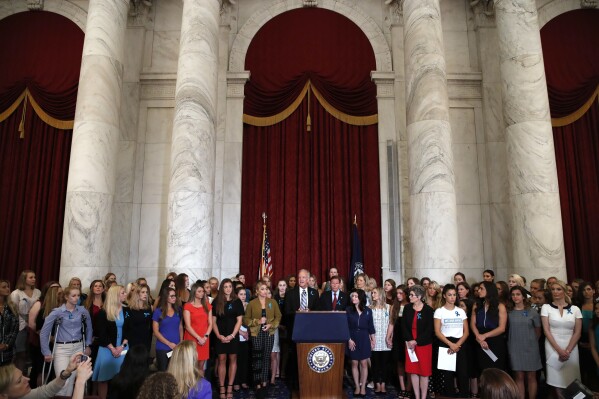 FILE - Sen. Jerry Moran, R-Kansas, center left, and Sen. Richard Blumenthal, D-Conn., attend a news conference with dozens of women and girls who were sexually abused by Larry Nassar, a former doctor for Michigan State University athletics and USA Gymnastics, July 24, 2018, on Capitol Hill in Washington. The U.S. Justice Department has agreed to pay approximately $100 million to settle claims with about 100 sexual assault victims of Nassar, a source with direct knowledge of the negotiations told The Associated Press on Wednesday, April 17, 2024. (AP Photo/Jacquelyn Martin, File)