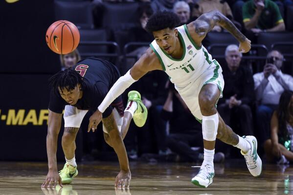 Southern California guard Boogie Ellis (5) and Oregon guard Rivaldo Soares (11) scramble after the ball during the second half of an NCAA college basketball game Thursday, Feb. 9, 2023, in Eugene, Ore. (AP Photo/Andy Nelson)