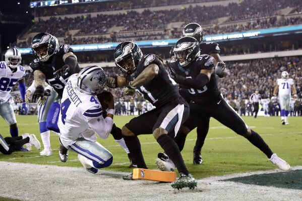 
              Dallas Cowboys quarterback Dak Prescott (4) is pushed out of bounds by Philadelphia Eagles defensive end Chris Long (56) and cornerback Ronald Darby (21) during the first half of an NFL football game, Sunday, Nov. 11, 2018, in Philadelphia. (AP Photo/Matt Slocum)
            