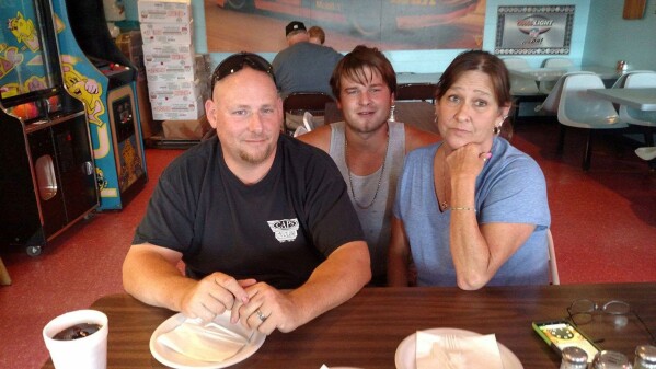 This August 2017 family photo shows Austin Hunter Turner with his mother, Karen Goodwin, and her husband, Brian, at a pizza restaurant in Bristol, Tenn., a week before Hunter's death. It was the last photo of them together. (Family photo via AP)