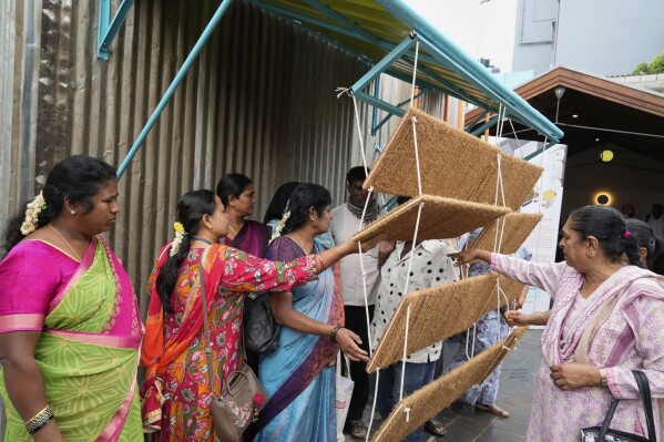 Daily wage workers, who mostly work outdoors, explore Neralu, an innovative portable heat shelter, at the Sweat and Concrete 2025 event in Bengaluru, India, Thursday, May 29, 2025. (AP Photo/Aijaz Rahi)