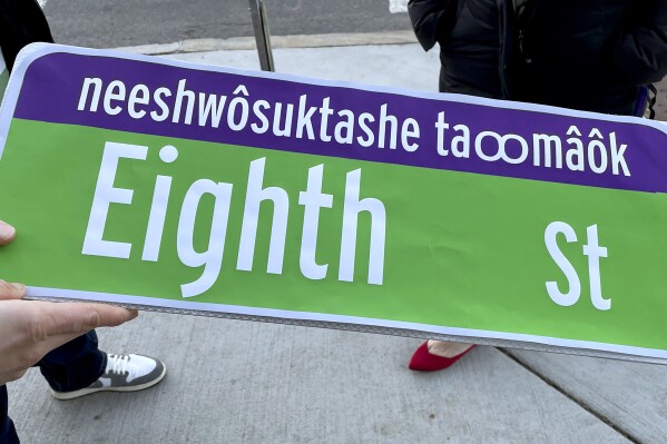 This photo taken on Dec. 14, 2023 provided by Sarah Burks shows a paper mockup of the street signs that will go up next year in some parts of Cambridge, Mass. and include the language of the Massachusett Tribe. (Sarah Burks via AP)