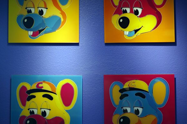 FILE - This Jan. 16, 2014 file photo shows paintings hanging  on a wall at Chuck E. Cheese's in Dallas. Chuck E. Cheese pizzeria, that Mecca of fun for children but the bane of many parents, is filing for bankruptcy protection. CEC Entertainment Inc. said Thursday, Jan. 25, 2020,  it was filing for voluntary protection under Chapter 11 “in order to overcome the financial strain resulting from prolonged, COVID-19 related venue closures.”  (G.J. McCarthy/The Dallas Morning News via AP)