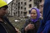 FILE - Olha Faichuk, 79, center, cries as she says goodbye to her neighbors in front of her apartment building, which was heavily damaged by a Russian airstrike, in Lukiantsi, Kharkiv region, Ukraine, on Tuesday, April 16, 2024. (AP Photo/Evgeniy Maloletka, File)