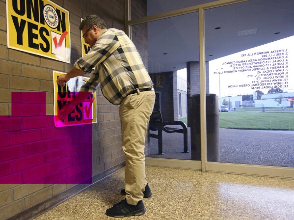 Brian Rothenburg with the United Auto Workers places signs at the International Brotherhood of Electrical Workers, Friday, June 14, 2019 in Chattanooga, Tennessee. Workers voted against forming a factory-wide union, handing a setback to the United Auto Workers’ efforts to gain a foothold among foreign auto facilities in the South. (Erin O. Smith/Chattanooga Times Free Press via AP)