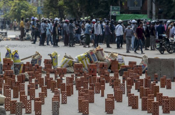 Anti-coup protesters stand behind makeshift barricades made with bricks in Mandalay, Myanmar, Wednesday, March 3, 2021. Demonstrators in Myanmar took to the streets again on Wednesday to protest last month's seizure of power by the military. (AP Photo)