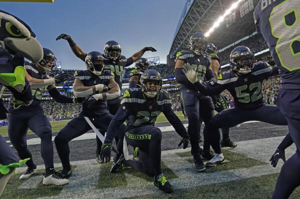 The Seattle Seahawks celebrate after an interception by safety Quandre Diggs during overtime of an NFL football game against the Los Angeles Rams Sunday, Jan. 8, 2023, in Seattle. (AP Photo/Abbie Parr)