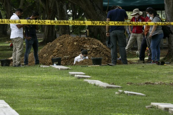 Forensic workers exhume what are believed to be the remains of Lt. Braulio Bethancourt, a victim of the 1989 U.S. invasion, at the Jardin de Paz cemetery in Panama City, Thursday, April 15, 2021.  The prosecutor’s office has begun an exhumation of human remains at the Panamanian cemetery in a renewed attempt to confirm the identities of the victims of the U.S. invasion. (AP Photo/Arnulfo Franco)