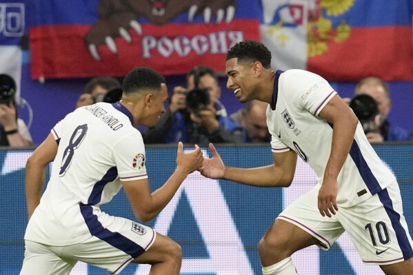 England's Jude Bellingham (10) celebrates his goal with Trent Alexander-Arnold during the first half in a Group C match between Serbia and England at the Euro 2024 soccer tournament in Gelsenkirchen, Germany, Monday, June 17, 2024. (AP Photo/Thanassis Stavrakis)