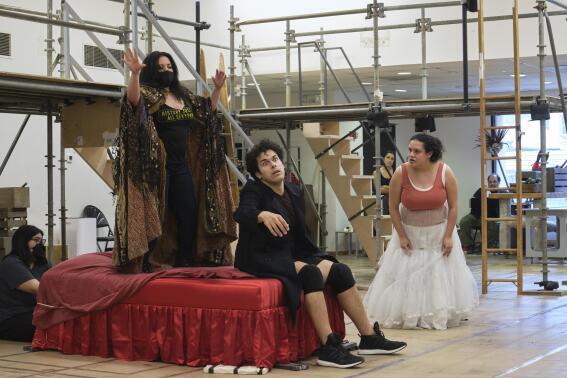 Actors Maria Christina-Oliveras, standing from left, Joel Perez and Desireé Rodriguez rehearse a scene from the musical comedy “Kiss My Aztec!” in Hartford, Conn., on May 12, 2022. The show, co-written by John Leguizamo and director Tony Taccone, will play at the Hartford Stage from June 1 to June 26. (Alan Arias via AP)