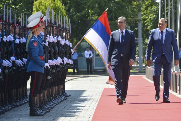 Serbian President Aleksandar Vucic, center, reviews the honour guard with Bosnian Serb leader Milorad Dodik during a welcome ceremony in Banja Luka, northern Bosnia, Friday, Aug. 4, 2023. Serbia will ignore U.S. sanctions recently imposed on top Bosnian Serb officials for undermining a 1995 peace agreement that ended a war that left more than 100,000 dead and millions homeless, the Serbian president said Friday. (AP Photo/Radivoje Pavicic)