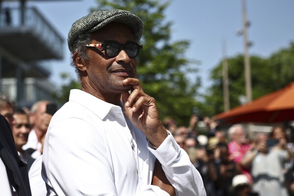 FILE - Former French tennis player and singer Yannick Noah looks on during the inauguration of a fresco retracing his life, on the 40th anniversary of his victory at Roland Garros in 1983, on day one of the Roland-Garros Open tennis tournament in Paris Sunday, May 28, 2023. Noah has been appointed captain of France’s wheelchair tennis men’s team and will lead the squad at the Paris Paralympic Games next year. Noah, a celebrity in his home country, guided France to Davis Cup titles in 1991, 1996 and 2017. He also captained France to its maiden victory in Fed Cup in 1997. (Anne-Christine Poujoulat, Pool via AP, File)