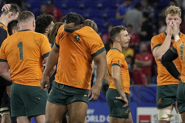 Australia's Pone Fa'Amausili covers his face after his side's 6-40 lost against Wales during a Rugby World Cup Pool C match at the Parc OL stadium in Lyon, France, Sunday, Sept. 24, 2023. (AP Photo/Laurent Cipriani)