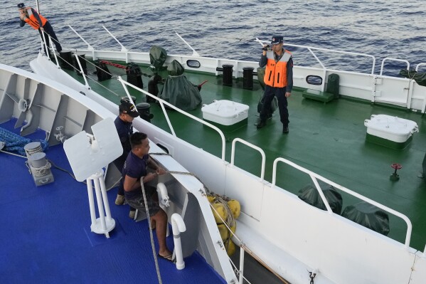 FILE - Philippine coast guard crew on BRP Sindangan lower their rubber fender as they collide with a Chinese coast guard vessel, right, who blocked their path while they tried to enter the Second Thomas Shoal, locally known as Ayungin Shoal, in the disputed South China Sea, Tuesday, March 5, 2024. The top American diplomat for East Asia and the Pacific criticized China on Thursday for using intimidation tactics against other countries in the region to press its sweeping maritime claims in the South China Sea. (AP Photo/Aaron Favila, File)