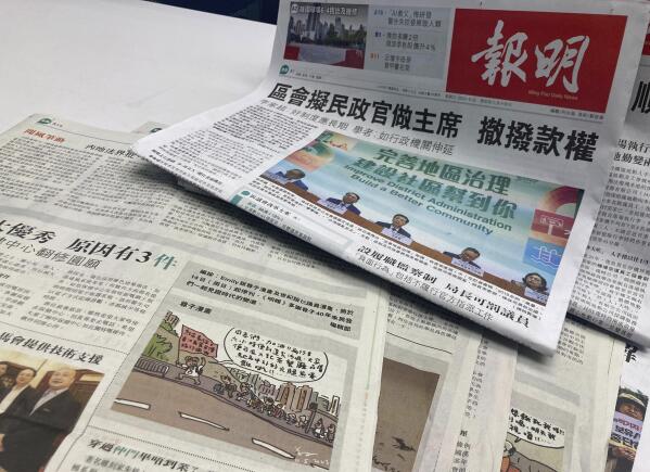 Copies of the Chinese-language newspaper Ming Pao and a cartoon by Wong Kei-kwan is set up for a photo in Hong Kong, Thursday, May 11, 2023. A Hong Kong newspaper will stop publishing works by the city's most prominent political cartoonist after his drawings drew government complaints, in another example of hushed speech and media voices after a Beijing-led crackdown. (AP Photo/Kanis Leung)