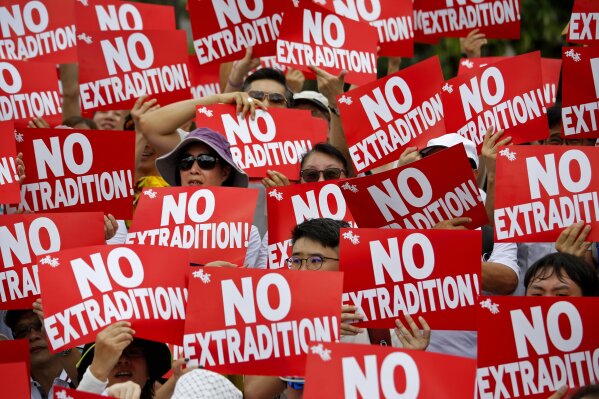 Protesters hold placards as they stage protest against the extradition law in Hong Kong, Sunday, June 9, 2019. The extradition law has aroused concerns that this legislation would undermine the city's independent judicial system as it allows Hong Kong to hand over fugitives to the jurisdictions that the city doesn't currently have an extradition agreement with, including mainland China, where a fair trial might not be guaranteed. (AP Photo)