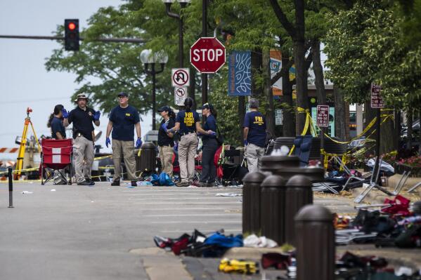 FILE - Members of the FBI Evidence Response Team Unit investigate in downtown Highland Park, Ill., on July 5, 2022, the day after a deadly mass shooting at a Fourth of July Parade. According to a lawsuit filed Wednesday, Sept. 28, 2022, in Illinois, the gunmaker Smith & Wesson illegally targeted young men at risk of violence with ads for firearms, including the 22-year-old gunman accused of opening fire on the Independence Day parade in suburban Chicago and killing seven people. (Ashlee Rezin/Chicago Sun-Times via AP, File)
