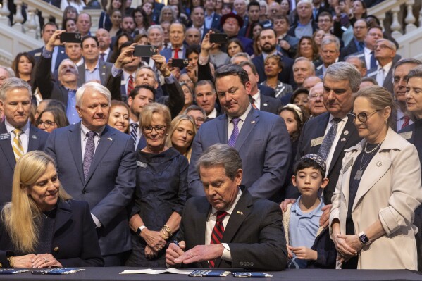 Gov. Brian Kemp signs an antisemitism bill HB 30 at the Capitol in Atlanta, on Wednesday, Jan. 31, 2024. (Arvin Temkar/Atlanta Journal-Constitution via AP)