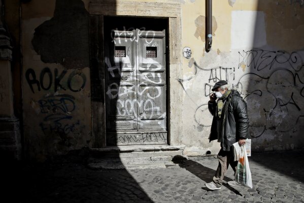 An elderly man wears a face mask as he walks in Rome's Trastevere neighborhood, Monday, March 16, 2020. The vast majority of people recover from the new coronavirus. According to the World  Health Organization, most people recover in about two to six weeks, depending on the severity of the illness. (AP Photo/Alessandra Tarantino)